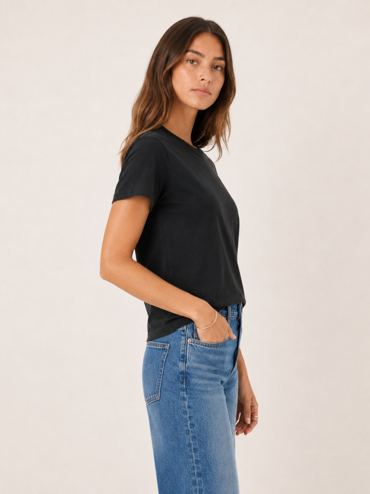 A woman wearing a black short-sleeve crewneck t-shirt 