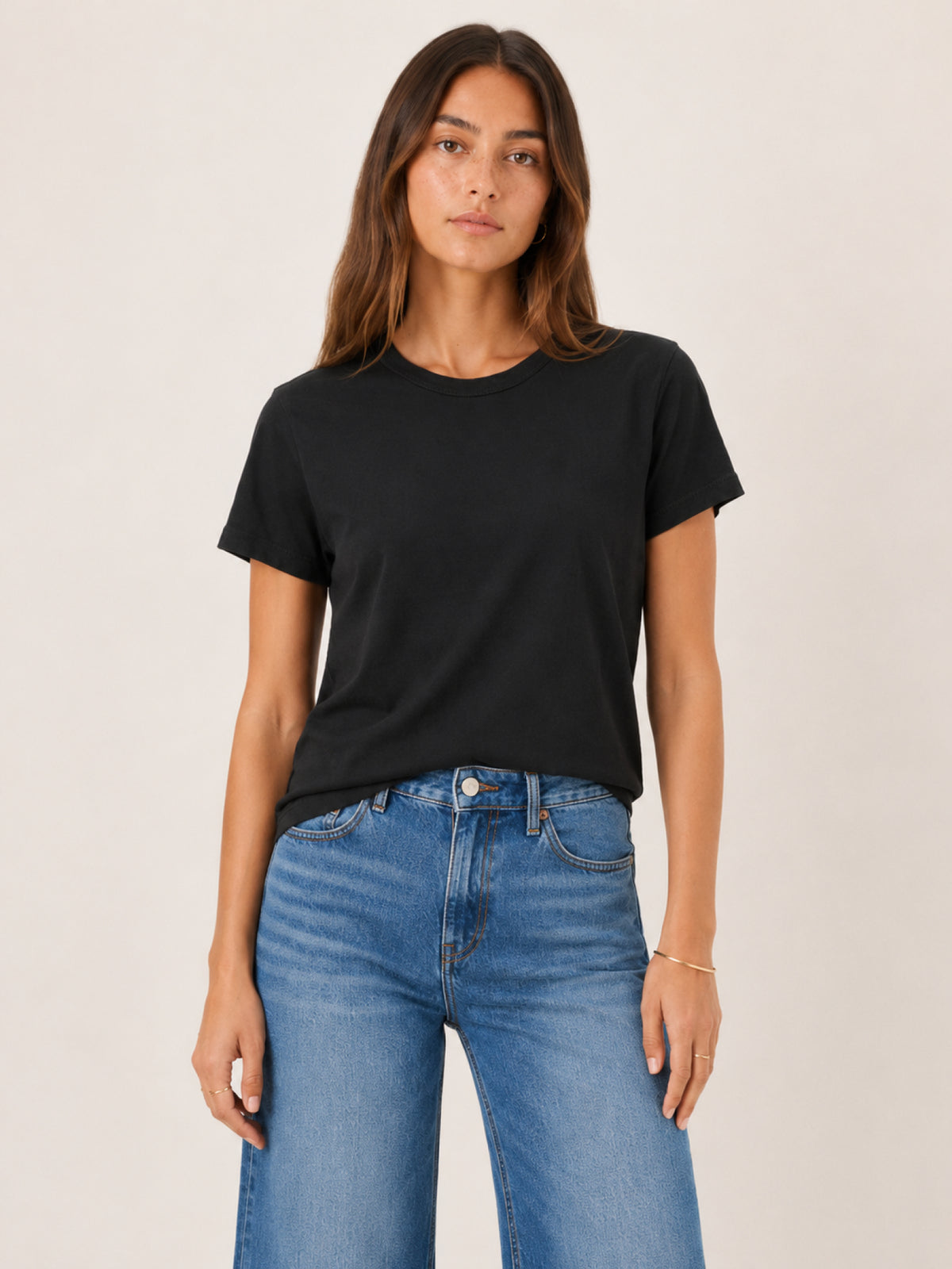 A woman wearing a black short-sleeve crewneck t-shirt 